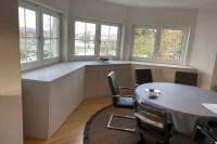 Holzschrank in weiß unter Fenstern