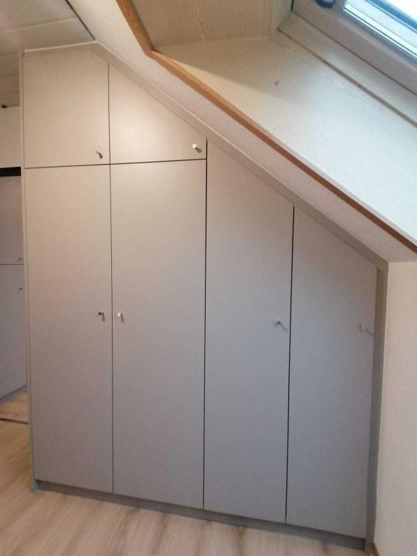 Eingebaute Holzschränke an Dachschräge