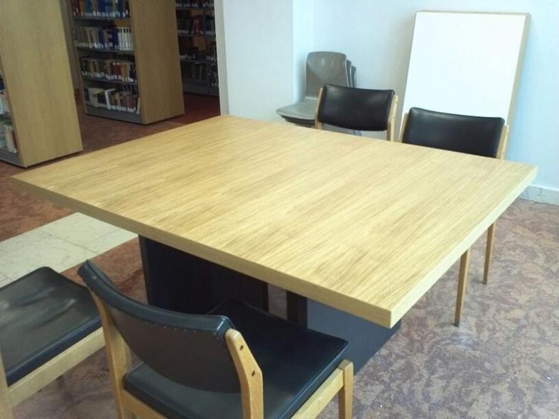 Holztisch mit Holzstühlen mit schwarzen Polstern