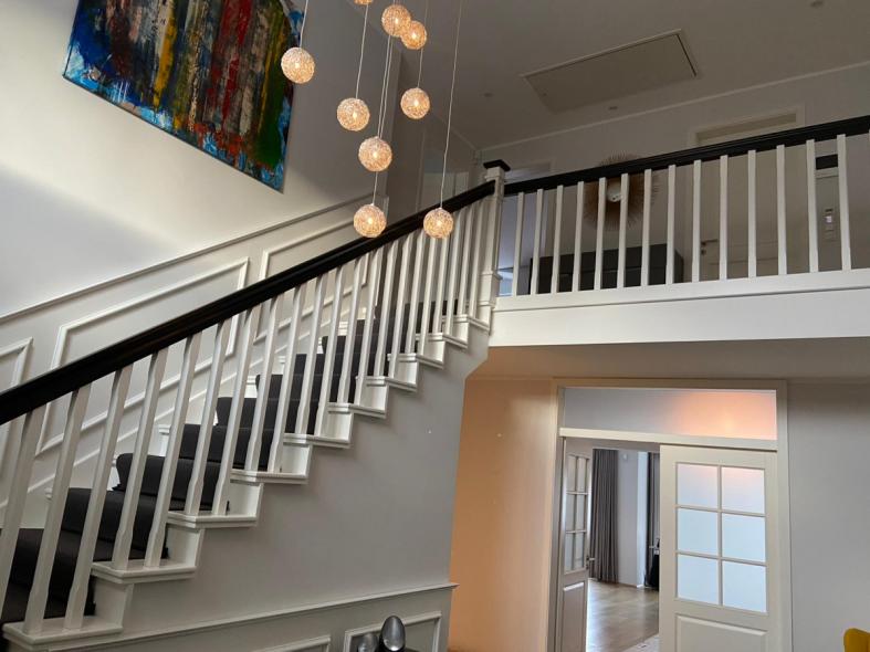 Holztreppe in weiß mit weiß/schwarzem Geländer