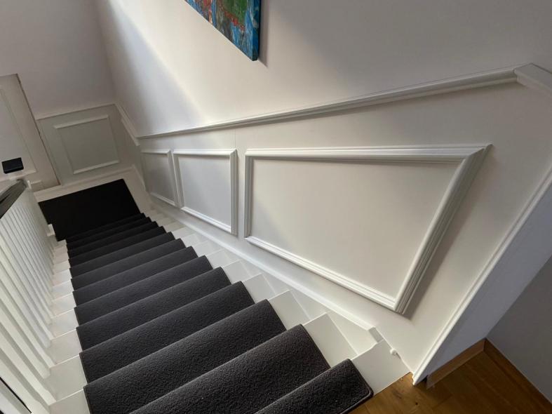 Holztreppe in weiß mit schwarzem Teppich: Ansicht von oben