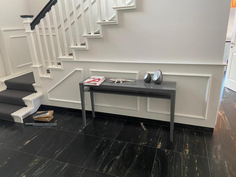 Holztreppe in weiß mit schwarzem Teppich mit Holzverkleidung an der Wand